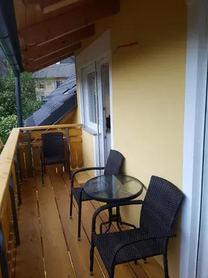 a balcony with chairs and a table on a porch at Apartmaji Zupan in Bohinjska Bela