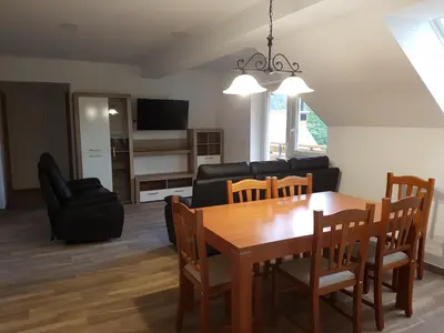 a living room with a table and chairs and a couch at Apartmaji Zupan in Bohinjska Bela