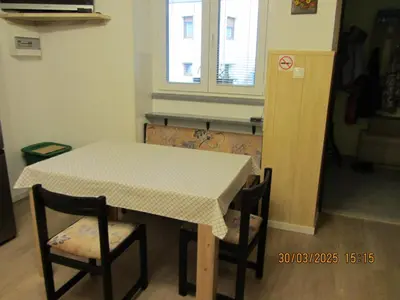 a table and chairs with a table and a window at Apartma Vilma in Kobarid