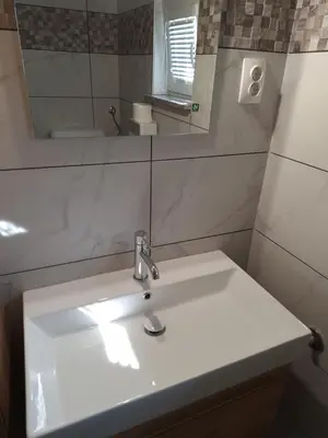 a bathroom with a white sink and a mirror at Apartma Vilma in Kobarid