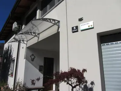 a white building with a door and a sign on it at Apartma Vilma in Kobarid