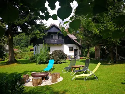 a group of chairs and a table in front of a house at River house HRIB in Preddvor