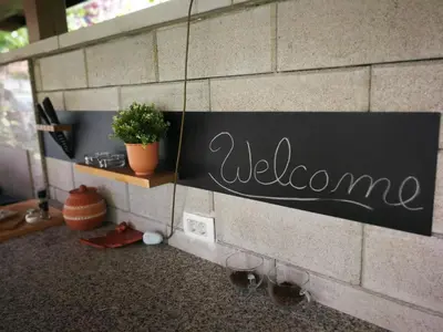 a welcome sign on a wall with wine glasses at River house HRIB in Preddvor