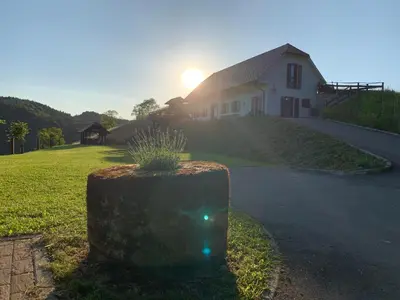 a house with the sun setting in the background at Tourist farm Artisek in Štore