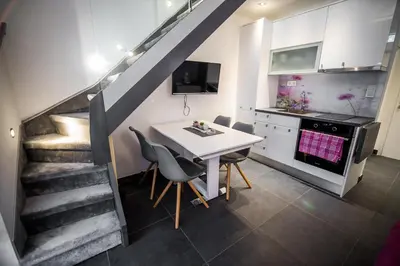 a kitchen with a table and chairs and a staircase at Golf apartment with SPA tickets discount in Moravske Toplice
