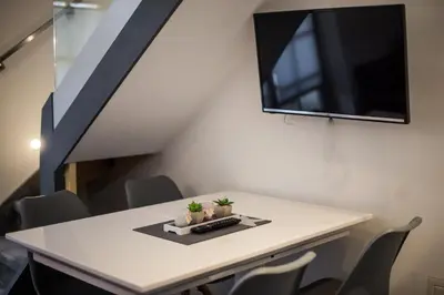 a white table with a tv on a wall with chairs at Golf apartment with SPA tickets discount in Moravske Toplice