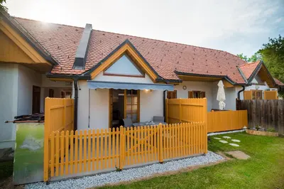 a house with a yellow fence in front of it at Golf apartment with SPA tickets discount in Moravske Toplice
