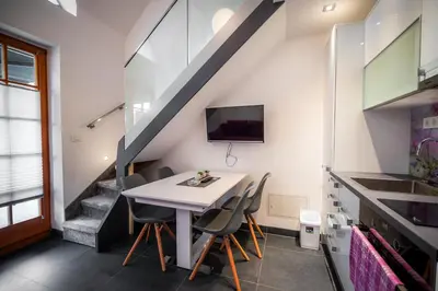 a dining room with a table and chairs and a staircase at Golf apartment with SPA tickets discount in Moravske Toplice