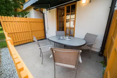 a table and chairs on a patio with a fence at Golf apartment with SPA tickets discount in Moravske Toplice