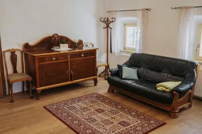 a living room with a leather couch and a dresser at Apartments Možinetova hiša in Šentjošt nad Horjulom