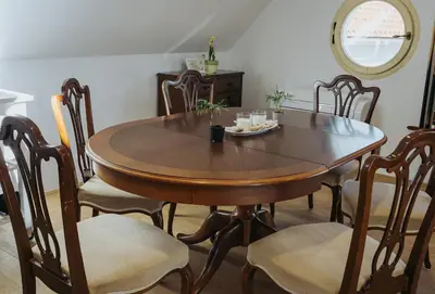 a dining room table and chairs with a table and a mirror at Apartments Možinetova hiša in Šentjošt nad Horjulom