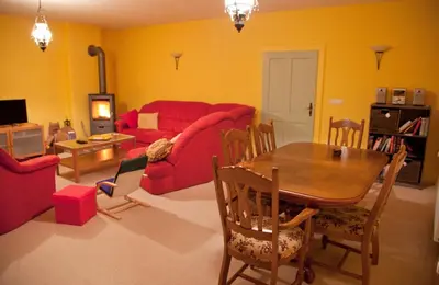 a living room with a red couch and a table at The 1882 Old House Vodnikova in Bohinj
