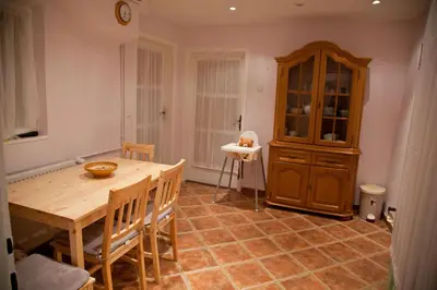a dining room with a wooden table and a cabinet at The 1882 Old House Vodnikova in Bohinj