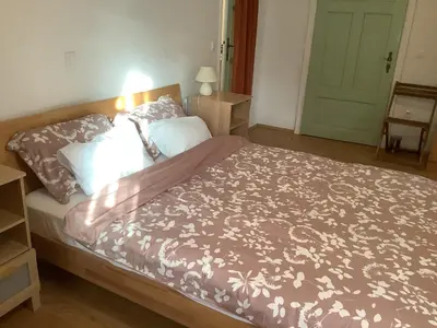 a bedroom with a bed with a brown comforter at The 1882 Old House Vodnikova in Bohinj
