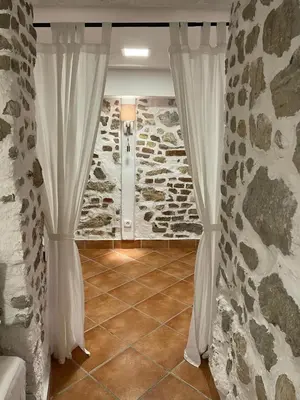 a room with white curtains and a stone wall at Villa Dei Sogni in Bled