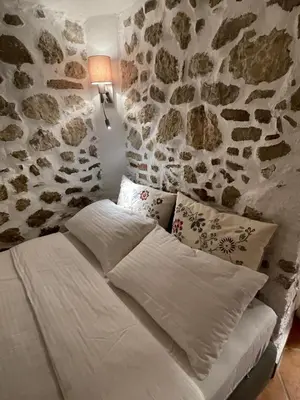 a bed in a room with a stone wall at Villa Dei Sogni in Bled
