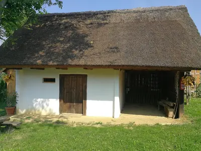 a small white house with a thatched roof at Hrgova hiška in Ptuj