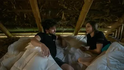 a man and a woman sitting on a bed at Hrgova hiška in Ptuj