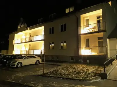 a white car parked in a parking lot in front of a building at Klass 302 in Kranjska Gora