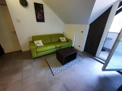 a living room with a green couch and a table at Klass 302 in Kranjska Gora