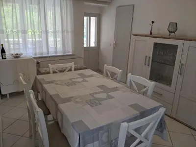 a dining room with a table and chairs and a kitchen at House by the Lake in Most na Soči