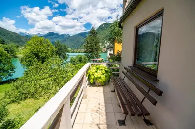 a balcony with a bench and a view of a lake at House by the Lake in Most na Soči