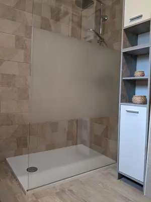 a shower with a glass door in a bathroom at House by the Lake in Most na Soči