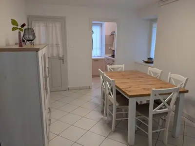 a kitchen and dining room with a wooden table and chairs at House by the Lake in Most na Soči