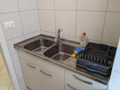 a kitchen sink with a dish rack next to it at House by the Lake in Most na Soči