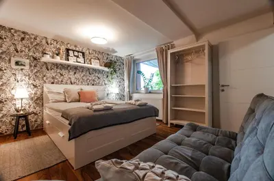 a bedroom with a bed and a couch at Apartma Amelie & Studio Mimi Bled in Bled