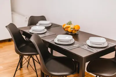 a dining room table with four chairs and a bowl of fruit at Apartma Amelie & Studio Mimi Bled in Bled