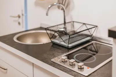 a kitchen counter with a sink and a drying rack at Apartma Amelie & Studio Mimi Bled in Bled