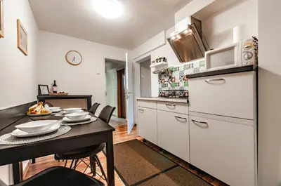 a kitchen and dining room with a table and a microwave at Apartma Amelie & Studio Mimi Bled in Bled