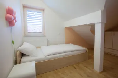 a small bedroom with a bed and a window at Luxury apartment Karolina in Bled