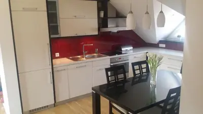 a kitchen with white cabinets and a table with chairs at Luxury apartment Karolina in Bled