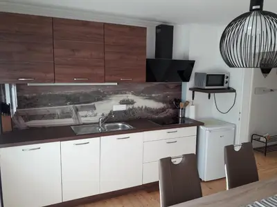 a kitchen with white cabinets and a sink at Apartments Justin in Bled
