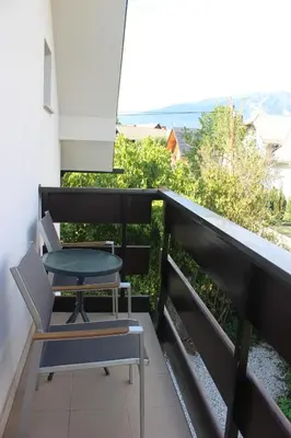 a table and chair on a balcony with a view at Mariana Apartment in Bled