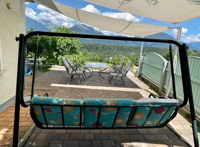 a swing on a patio with a table and chairs at Apartma AS in Bled