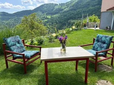 two chairs and a table with a vase of flowers at Pr' Grogori in Železniki