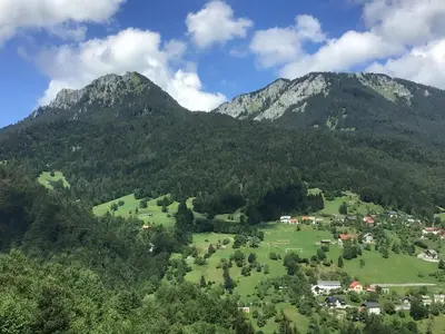 a village in a green field in front of mountains at Pr' Grogori in Železniki