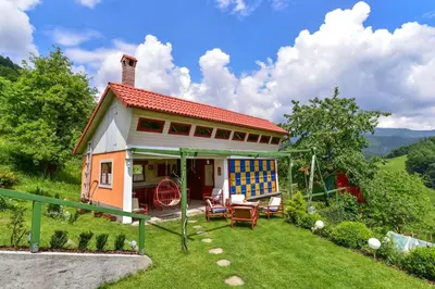 a small house with a patio and chairs in the yard at Pr' Grogori in Železniki