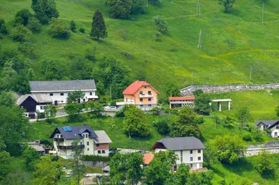 a group of houses on a green hill at Pr' Grogori in Železniki