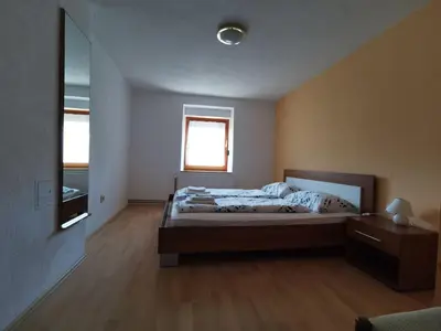 a bedroom with a large bed and a mirror at Apartma Jerman in Kranjska Gora