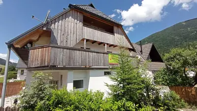 a house with a wooden roof on top of it at Apartma Jerman in Kranjska Gora