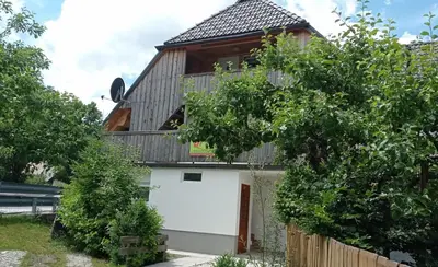 a wooden house with a garage and a fence at Apartma Jerman in Kranjska Gora