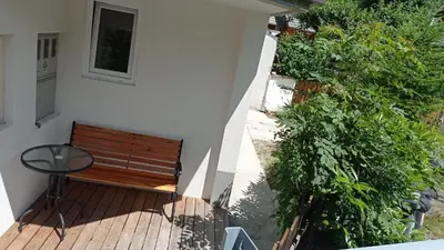 a wooden bench sitting on a deck next to a building at Apartma Jerman in Kranjska Gora