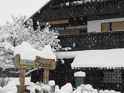 a snow covered sign in front of a building at Snežak (Snowman) 2 in Bohinj
