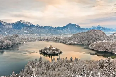 an island in the middle of a lake with mountains at Snežak (Snowman) 2 in Bohinj
