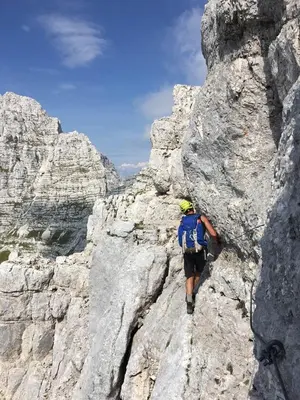 a man is climbing on a rocky mountain at Snežak (Snowman) 2 in Bohinj