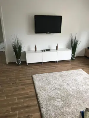 a white living room with a tv on a wall at Jure apartment in Ljubljana in Ljubljana